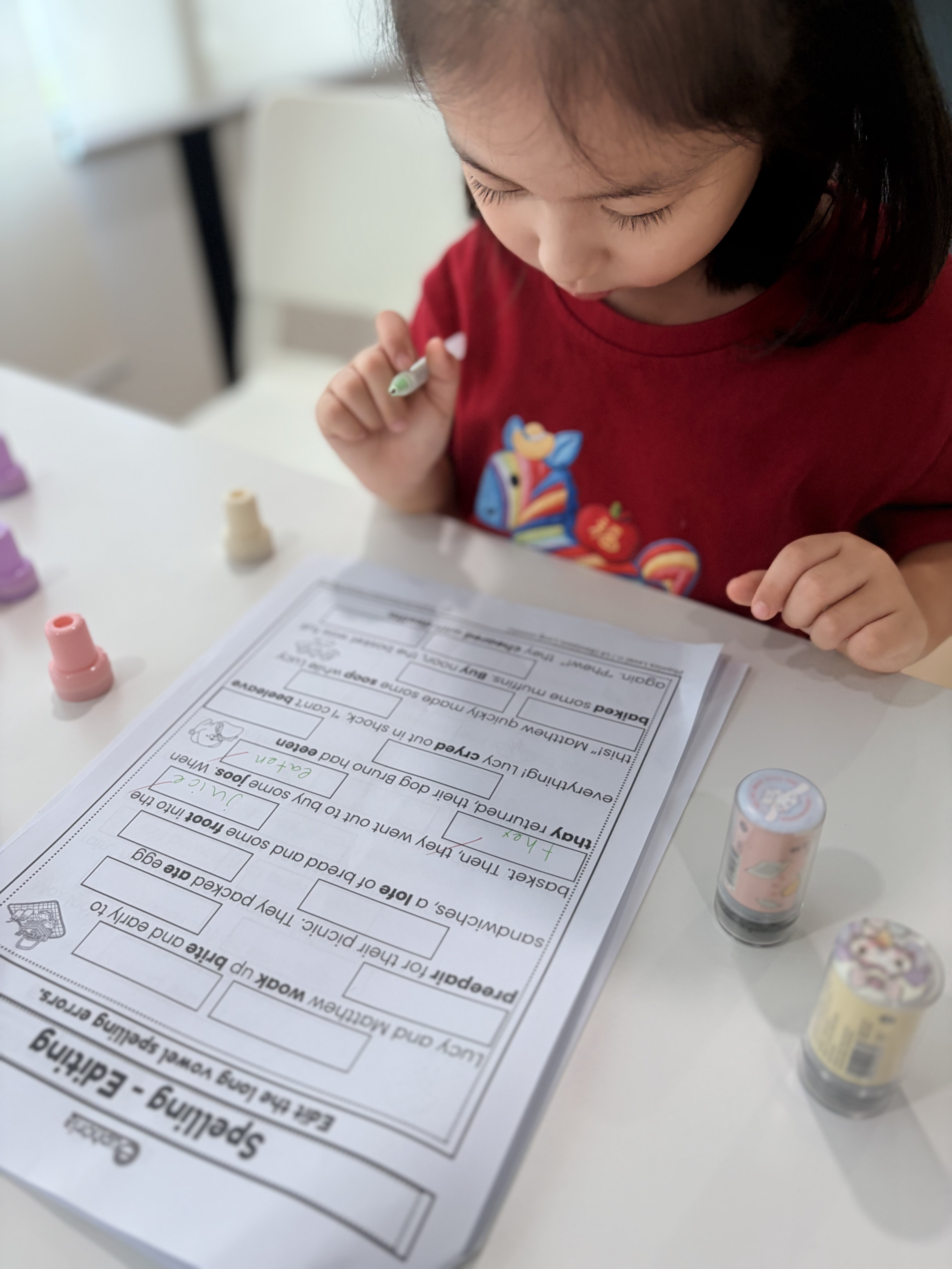 A pupil working on spelling and word forms at a classroom table